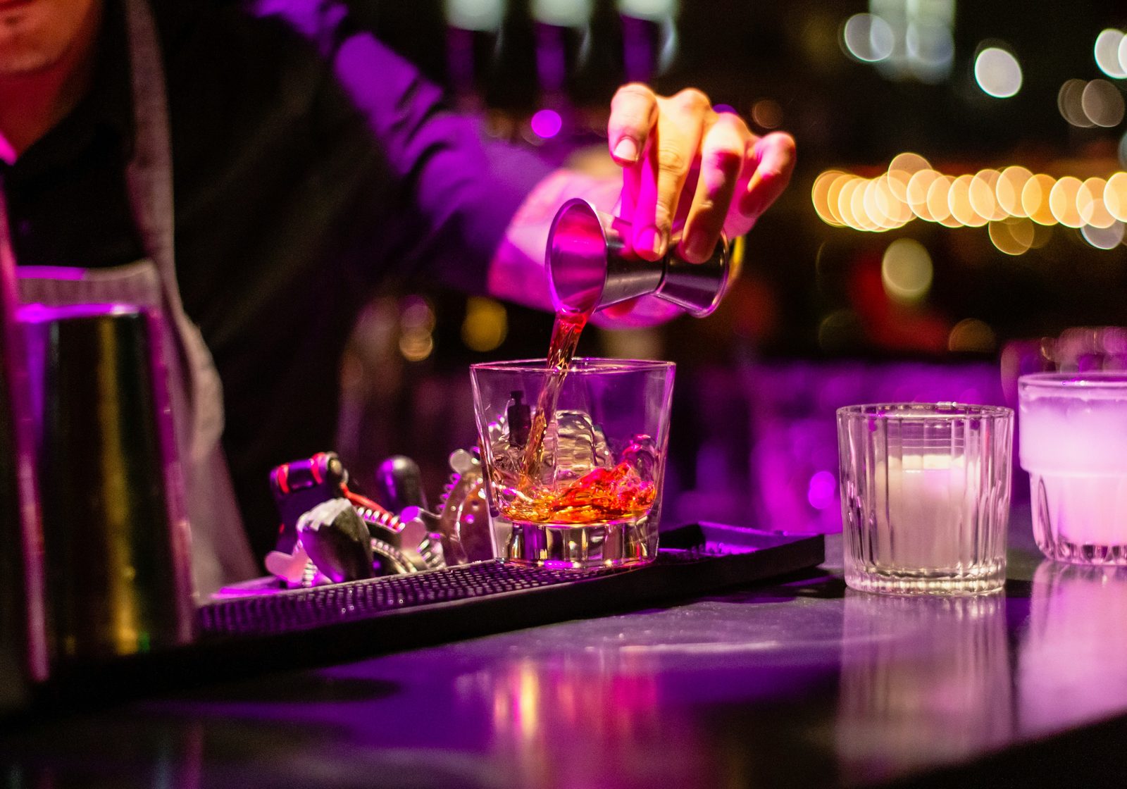 Barman schenkt een cocktail in tijdens het uitgaan